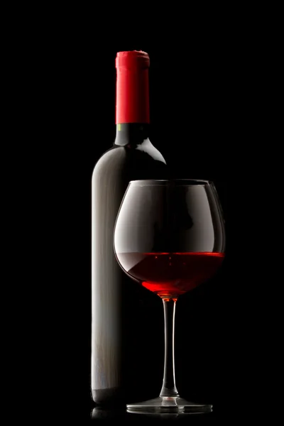 Garrafa com vinho tinto e vidro — Fotografia de Stock
