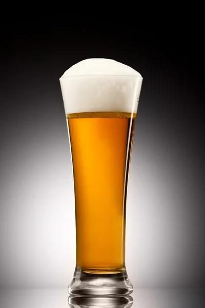 Beer into glass on a gray gradient — Stock Photo, Image