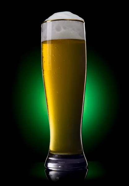 Beer into glass on a green gradient — Stock Photo, Image