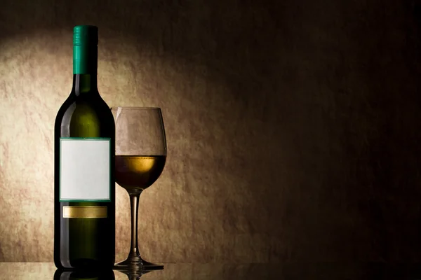 Garrafa com vinho branco e vidro em uma pedra velha — Fotografia de Stock