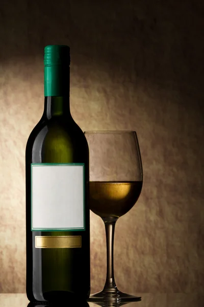 Fles met witte wijn en glas op een oude steen — Stockfoto