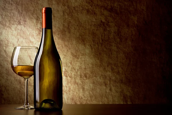 Flasche mit Weißwein und Glas auf einem alten Stein. Flasche in der f — Stockfoto