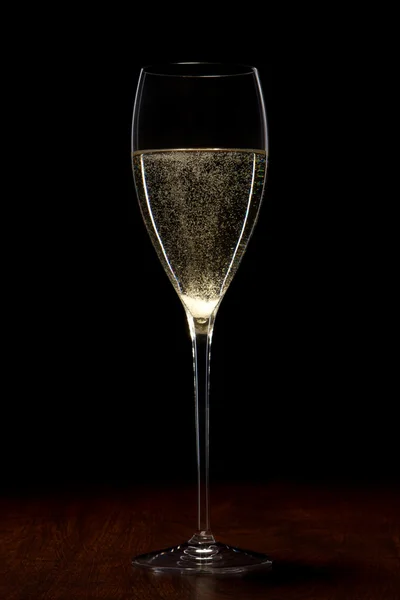 Szkło z szampanem na drewnianym stołem — Zdjęcie stockowe