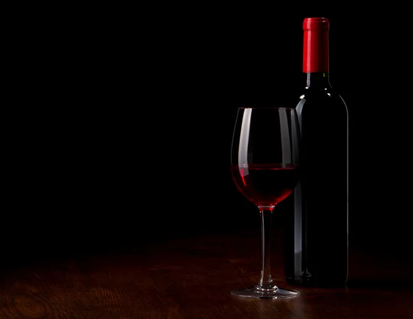Copo de vinho e garrafa em uma mesa de madeira — Fotografia de Stock