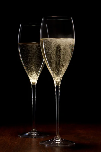 Dwa szkła z szampanem na drewnianym stołem — Zdjęcie stockowe