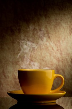 Yellow cup of coffee on a old stone background. clipart