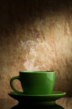 Green cup of coffee on a old stone background. clipart