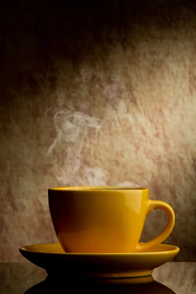 Taza de café amarillo sobre un viejo fondo de piedra . — Foto de Stock
