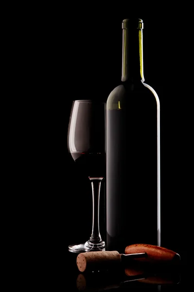 Μπουκάλι με κόκκινο κρασί και γυαλί και το φελλό με ένα τιρμπουσόν πάνω σε μαύρο — Φωτογραφία Αρχείου