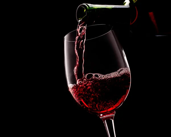 Красное вино на черном фоне — стоковое фото