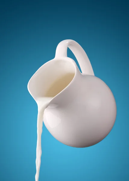 Krug Milch auf blauem Hintergrund — Stockfoto