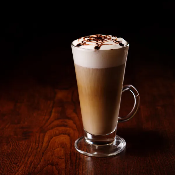 Kubek latte na drewnianym stołem — Zdjęcie stockowe