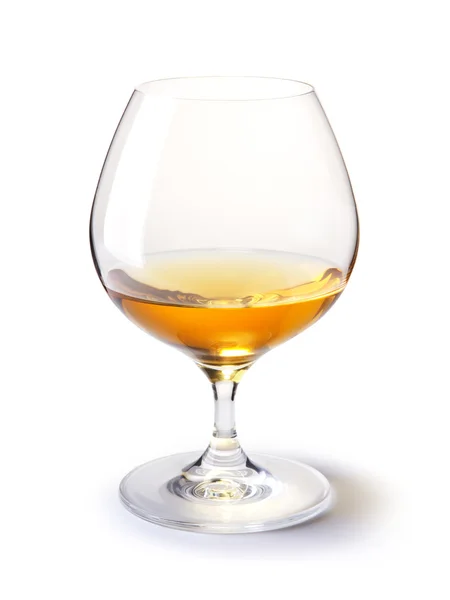 Ποτήρι κονιάκ ή μπράντυ με χρυσό κονιάκ πάνω σε άσπρο με σκιά — Φωτογραφία Αρχείου