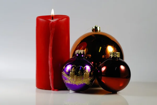 Красная свеча с рождественским шаром — стоковое фото