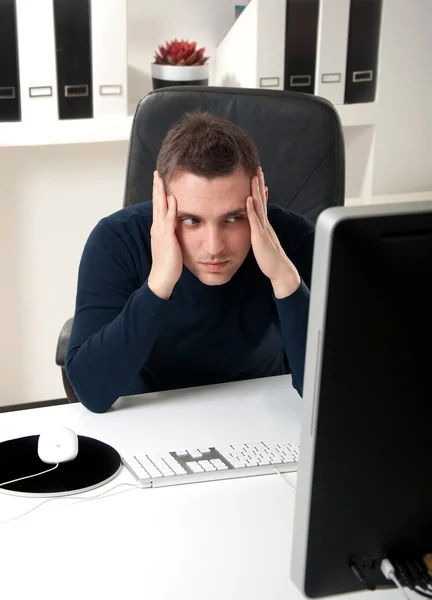 Young man thinking in front of his computer — Stock Photo, Image