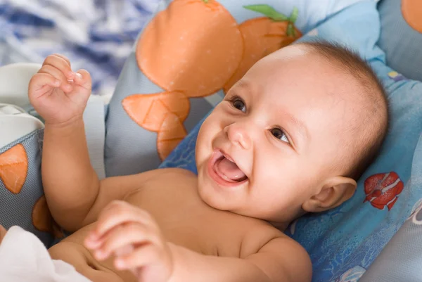 Smiling newborn on a bed — Stock Photo, Image