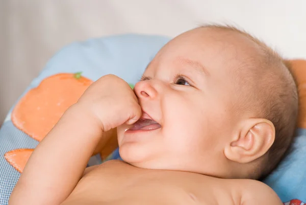 Smiling newborn on a bed — Stock Photo, Image