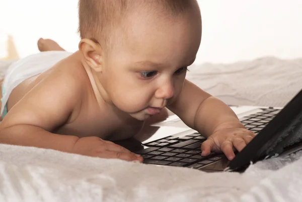 Baby och en bärbar dator — Stockfoto
