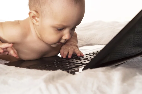 Baby och en bärbar dator — Stockfoto
