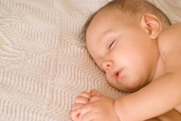 Güzel bebek uyku üzerinde beyaz bir — Stok fotoğraf