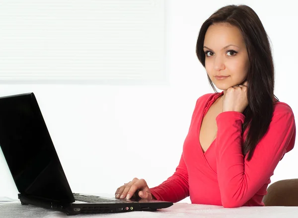 Girl in the red with a laptop — Stock Photo, Image