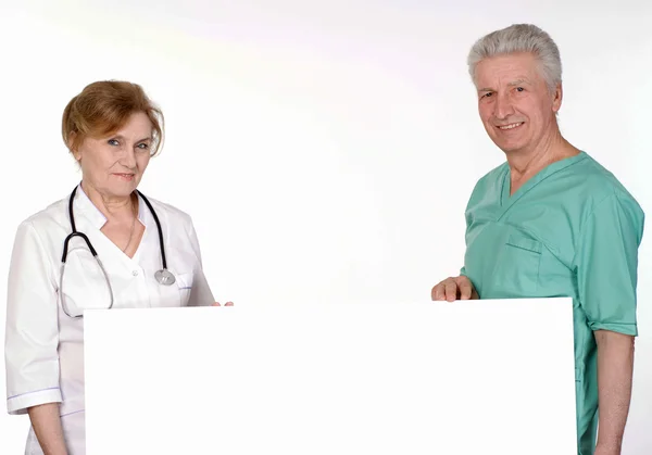 Kaksi vanhempaa lääkäriä valkoisella — kuvapankkivalokuva