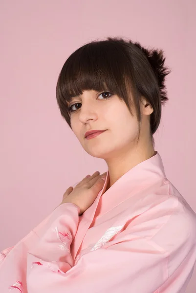 Meisje permanent op een roze — Stockfoto