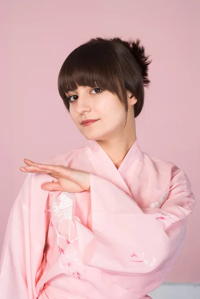 Mädchen steht auf einem rosa — Stockfoto