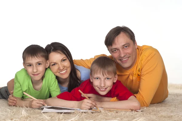 Bela família desenhando em um tapete — Fotografia de Stock