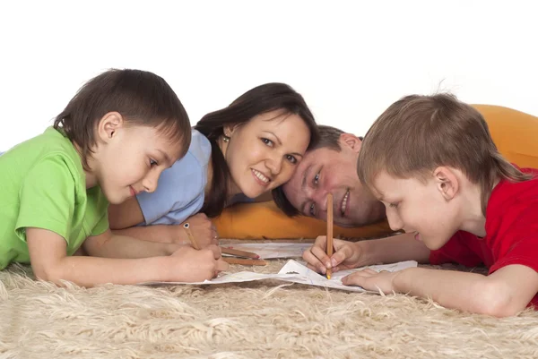 Leuke familie puttend uit een tapijt — Stockfoto