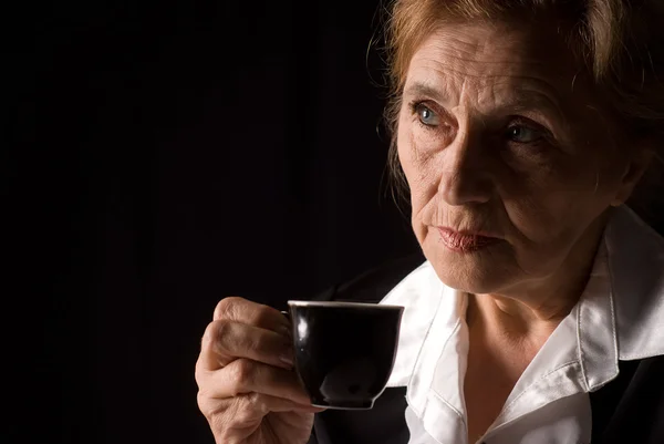 Пожилая женщина пьет — стоковое фото