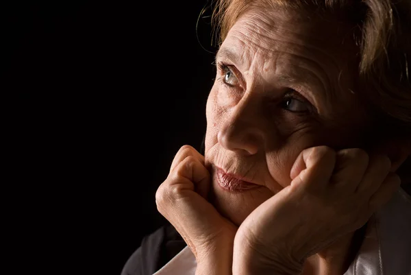 Old woman on black — Stock Photo, Image