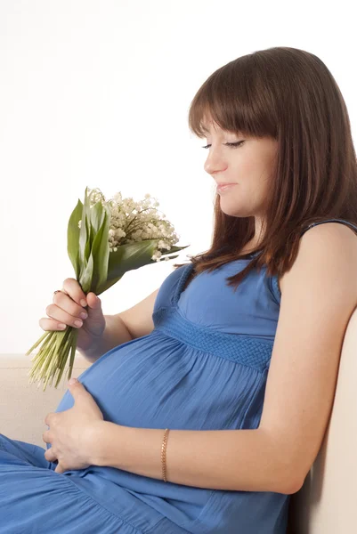 Беременная девушка сидит — стоковое фото