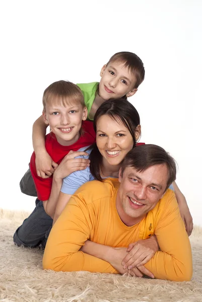 Família feliz em um carpete — Fotografia de Stock