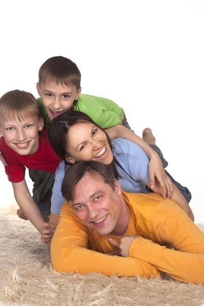 Glückliche Familie auf einem Teppich — Stockfoto