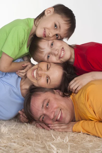 Familia feliz en una alfombra — Foto de Stock
