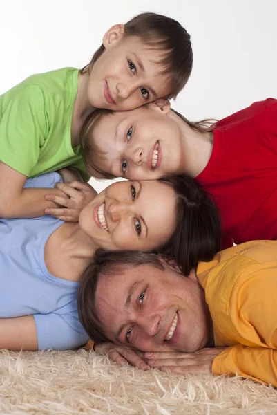 Familia feliz en una alfombra — Foto de Stock