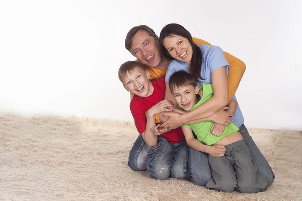 Familia feliz en una alfombra —  Fotos de Stock