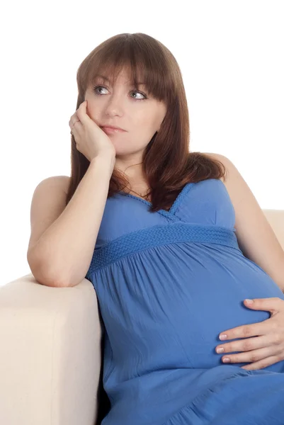 Беременная девушка на диване — стоковое фото