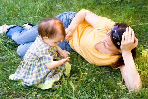 Mamma och barn på en gräs — Stockfoto