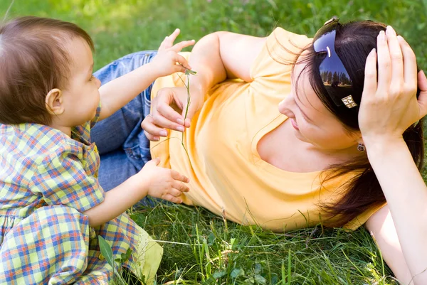Mamma e bambino su un'erba — Foto Stock