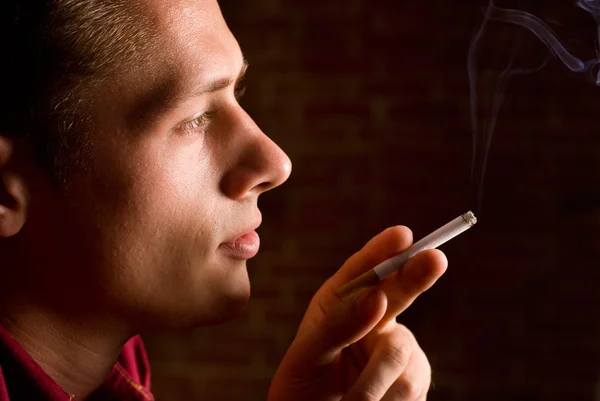 Fiatal férfi cigarettával — Stock Fotó
