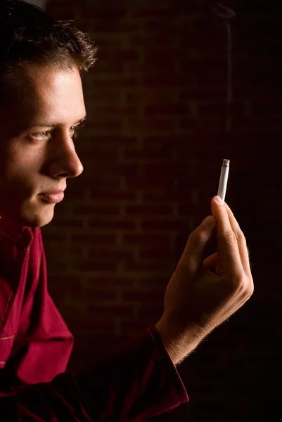 Nuori mies savukkeen kanssa — kuvapankkivalokuva