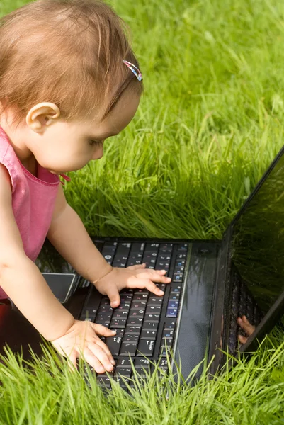 Liten flicka med bärbar dator — Stockfoto