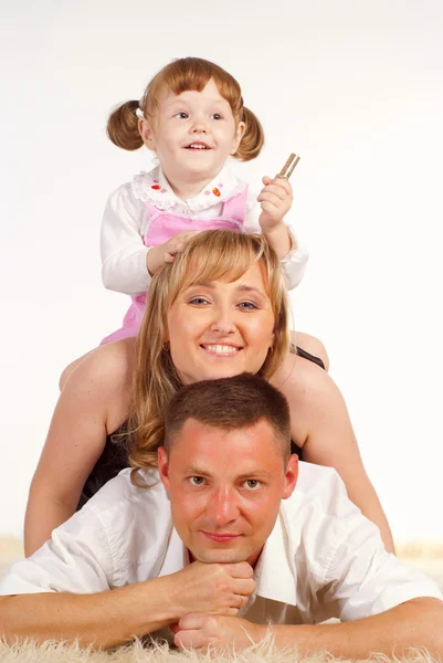 Söt familj på mattan — Stockfoto