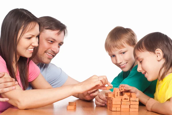 Leuke familie aan tafel spelen — Stockfoto
