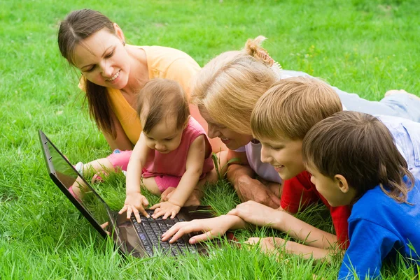 笔记本电脑在草地上的家庭 — 图库照片
