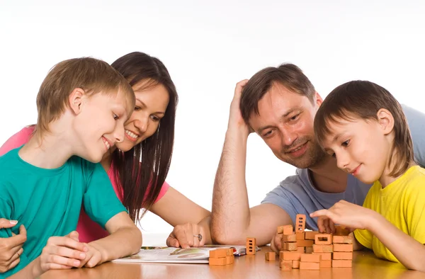 Familia feliz jugando en la mesa — Foto de Stock