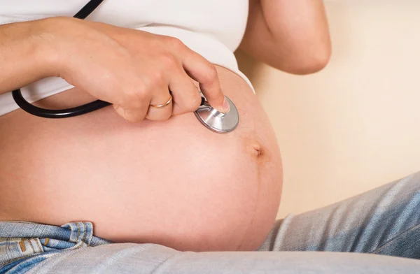 Беременная женщина со стетоскопом — стоковое фото