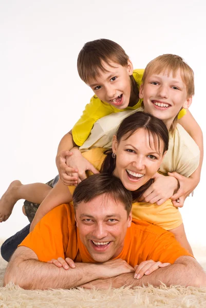 Família feliz no tapete — Fotografia de Stock